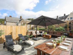 a patio with a wooden table and an umbrella at The Old School in Conwy