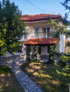 Biały dom z balkonem i dziedzińcem w obiekcie Woods cottage Loutra Pozar Aridaia w mieście Megaplátanos