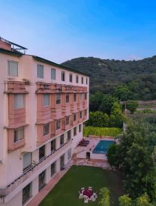 an apartment building with a yard and a swimming pool at WelcomHeritage Mount Valley Resort Ranthambore in Sawāi Mādhopur