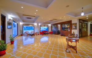 a large lobby with chairs and tables in a building at WelcomHeritage Mount Valley Resort Ranthambore in Sawāi Mādhopur