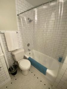 a white bathroom with a toilet and a bath tub at Furnished Apartments - Climate Pledge Arena Next Door in Seattle