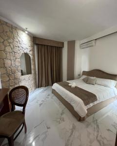 Villa Edelweiss في باكولي: غرفة نوم بسرير كبير وجدار حجري