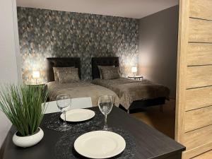 um quarto com 2 camas e uma mesa com copos em Aizkraukle Penthouse apartment em Aizkraukle