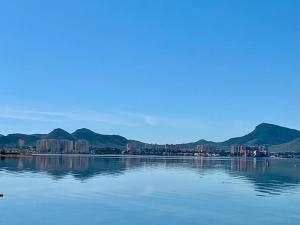 een grote hoeveelheid water met bergen op de achtergrond bij CHALET CON PISCINA A 100m DE LA PLAYA LA MANGA in La Manga del Mar Menor