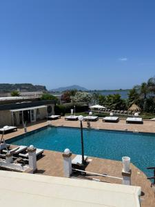 a swimming pool with chaise lounge chairs at Villa Edelweiss in Bacoli