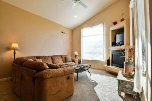 a living room with a brown couch and a tv at Rim Village M4 in Moab
