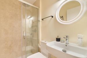 a bathroom with a shower and a sink and a mirror at Hostal Evocare Madrid in Madrid