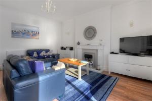 a living room with a couch and a table and a tv at 2 Mareeba in Seaton