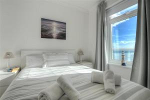 a bedroom with a large white bed with a window at 2 Mareeba in Seaton