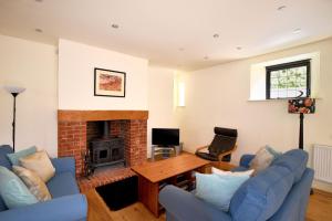 a living room with blue couches and a fireplace at Yard Cottage in Lyme Regis