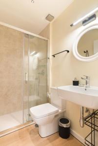 a bathroom with a toilet and a sink and a shower at Hostal Evocare Madrid in Madrid