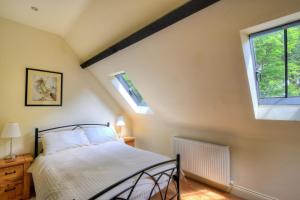 a bedroom with a bed and a window at Yard Cottage in Lyme Regis