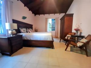 a bedroom with a bed and a table and a chair at Kismet Garden Cottages - Dover Beach in Christ Church
