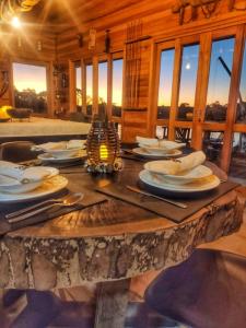 een houten tafel met borden en keukengerei erop bij Aka Fishing Lodge in Guarapuava