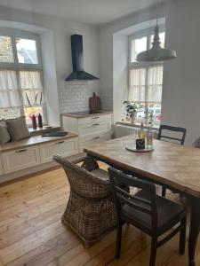 una cocina con mesa de madera y sillas. en Residenz Moselliebe en Traben-Trarbach