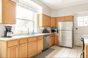 a kitchen with wooden cabinets and a stainless steel refrigerator at Lovely Family Friendly Home- Free Parking in Evanston