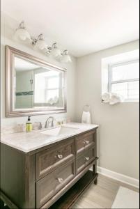 a bathroom with a sink and a mirror at Lovely Family Friendly Home- Free Parking in Evanston