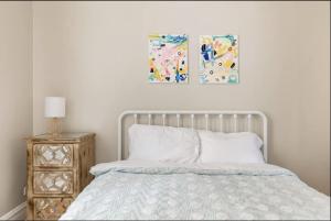 a bedroom with a bed and two paintings on the wall at Lovely Family Friendly Home- Free Parking in Evanston