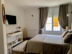 een witte slaapkamer met een bed en een raam bij Fontevraud Les Chambres in Fontevraud-l'Abbaye
