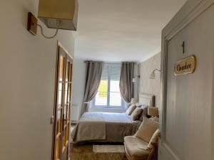 1 dormitorio con cama, ventana y sofá en Fontevraud Les Chambres, en Fontevraud-l'Abbaye