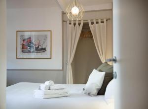 a bedroom with a bed with towels and a chandelier at Locanda 53 in Arco
