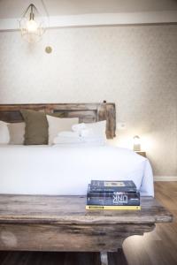a bed with a stack of books on a wooden table at Locanda 53 in Arco