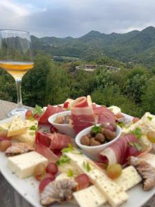 a plate of cheese and meats and a glass of wine at Skadar Lake Family Resort in Rijeka Crnojevića