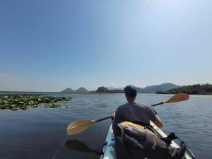 a man in a kayak on the water at Skadar Lake Family Resort in Rijeka Crnojevića
