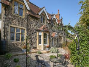 ein altes Steinhaus mit einem Tor davor in der Unterkunft Gable Lodge in Great Malvern