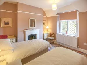 a bedroom with two beds and a fireplace at Gable Lodge in Great Malvern