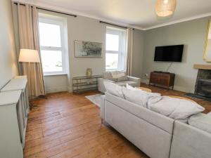 a living room with a couch and a tv at Bodorgan Inn in Bodorgan