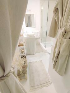 Baño blanco con ducha y alfombra en STUDIO AU CŒUR DE GUELIZ en Marrakech
