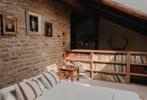 a room with a brick wall with a bed and a table at Honey home in Bistriţa