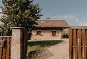 a brick house with a gate and a fence at Honey home in Bistriţa