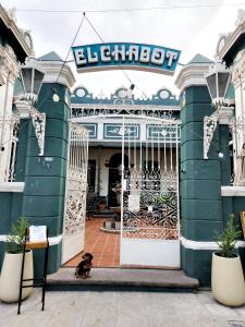 un chien assis devant un bâtiment avec un portail dans l'établissement El Chabot Fan, à Salta