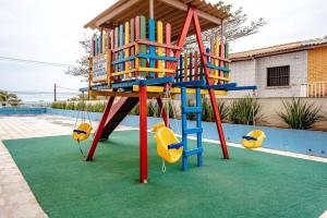 a playground with a ladder and swings on a green carpet at APARTAMENTO, ATÉ 4 PESSOAS,20 Metros da PRAIA do SONHO, PÉ NA AREIA,100 MB WI-FI in Itanhaém