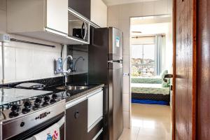 a kitchen with a stainless steel refrigerator and a sink at APARTAMENTO, ATÉ 4 PESSOAS,20 Metros da PRAIA do SONHO, PÉ NA AREIA,100 MB WI-FI in Itanhaém