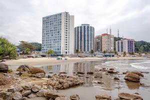 een strand met hoge gebouwen op de achtergrond van een stad bij APARTAMENTO, ATÉ 4 PESSOAS,20 Metros da PRAIA do SONHO, PÉ NA AREIA,100 MB WI-FI in Itanhaém