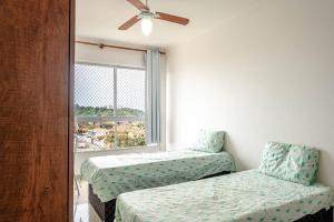 a room with two beds and a window at APARTAMENTO, ATÉ 4 PESSOAS,20 Metros da PRAIA do SONHO, PÉ NA AREIA,100 MB WI-FI in Itanhaém