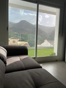 sala de estar con sofá y ventana grande en Apartamento Isabella suite, en Güéjar-Sierra