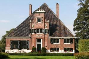 duży ceglany dom z dwoma kominami w obiekcie Studio, 21 minutes by bus to downtown Amsterdam w mieście Purmerend