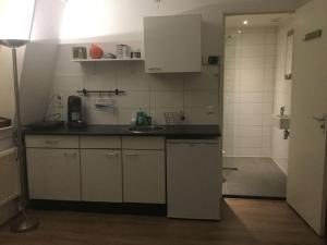 a small kitchen with a sink and a shower at Studio, 21 minutes by bus to downtown Amsterdam in Purmerend