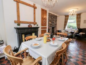 a dining room with a table and chairs and a fireplace at Wenallt in Caernarfon