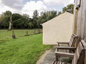 a wooden bench sitting next to a fence at Wenallt in Caernarfon