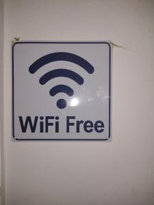 a sign on a wall with a wifi free sign at Periklis House in Ixia