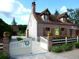 a house with a white fence and a gate at Gite de Sologne "les galoches" in Dhuizon