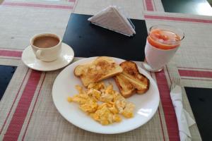 a plate of food with toast and a cup of coffee at Ayenda RM in Barrancabermeja