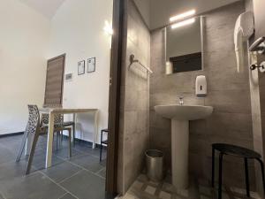 a bathroom with a sink and a table with chairs at Hostel Turin Metro Young in Turin