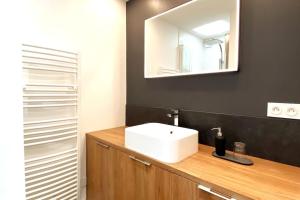 y baño con lavabo blanco y espejo. en Appartement CENTRE DES CONGRES - BALCON - FACULTES - PARKING en Angers