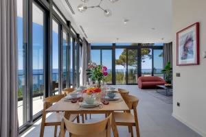 - une salle à manger avec une table, des chaises et des fenêtres dans l'établissement Kuk Oaza Luxury Villas, à Makarska